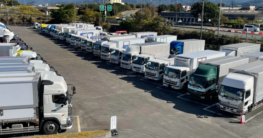 写真：駐車場に並んでいる多数のトラック